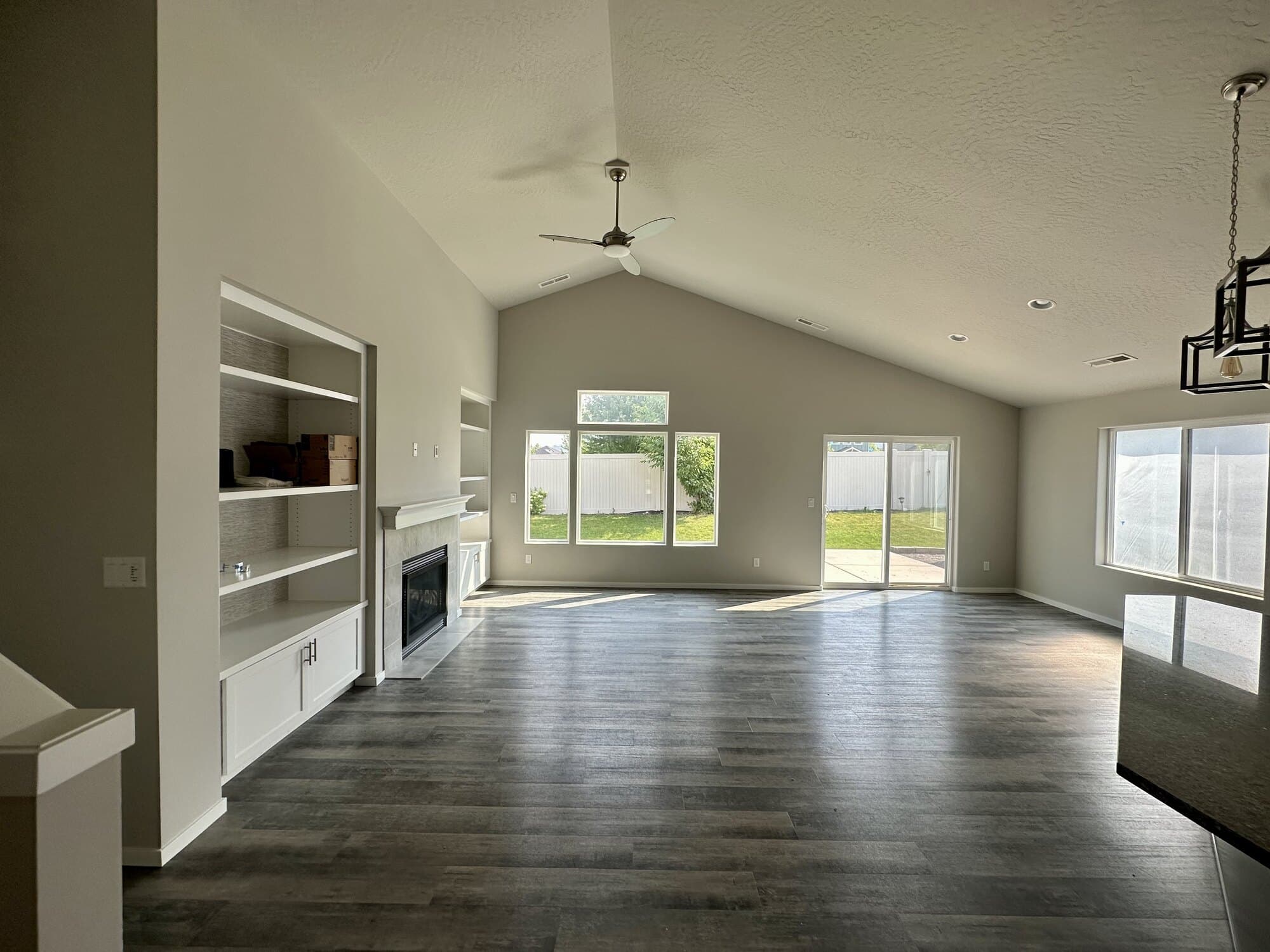 Vaulted living room with painted walls, white trim, and built-in shelving